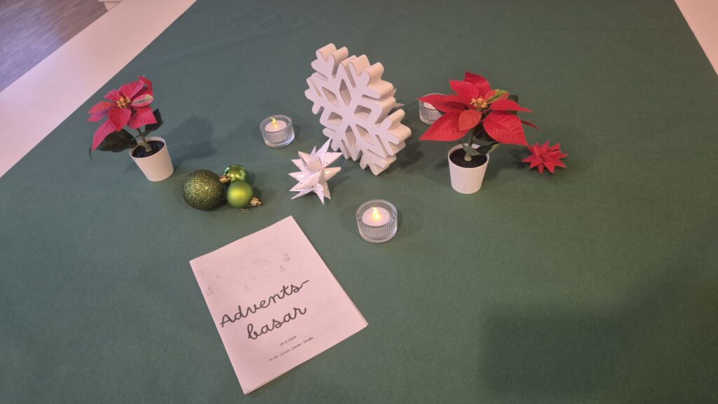 Tischdeko mit Weihnachtssternen und Schild „Adventsbasar“