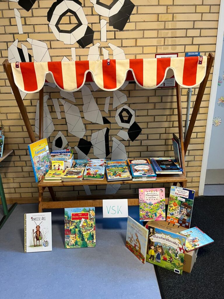 Bücherstand mit gestreiftem Marktdach und ausgelegten Büchern