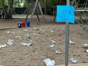 Sandkasten voller Verpackungsmüll an der Station zum Thema Müll