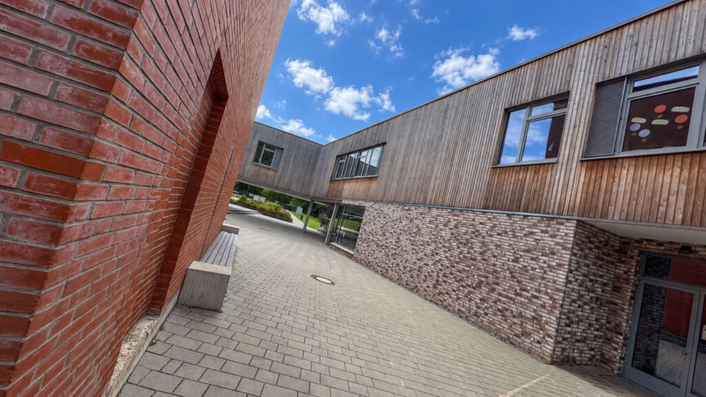 Klinkerwand und Holzfassade am Eingang zum Innenhof