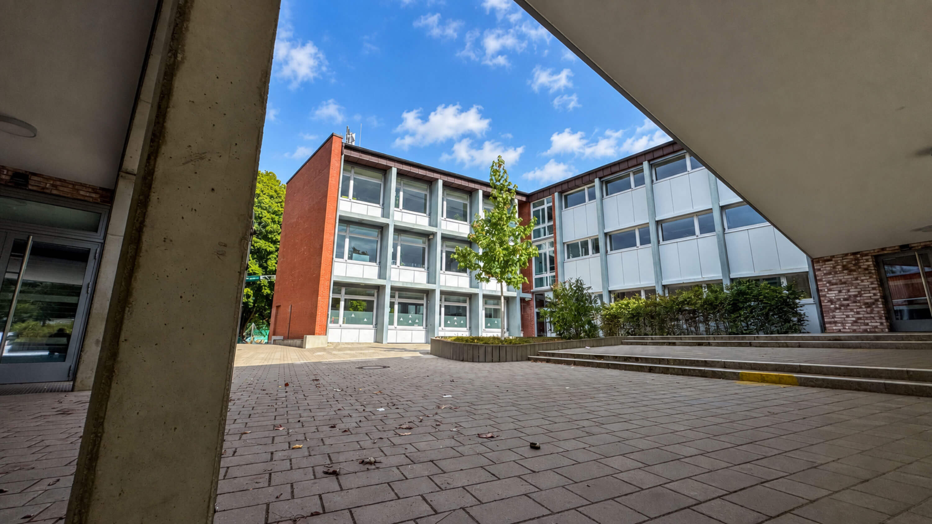 Schulhof mit Blick auf die mehrgeschossigen Klassentrakte