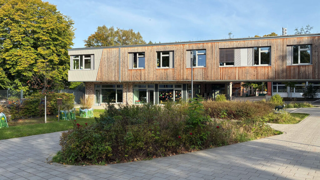 Holzverkleideter Schulneubau mit begrüntem Innenhof