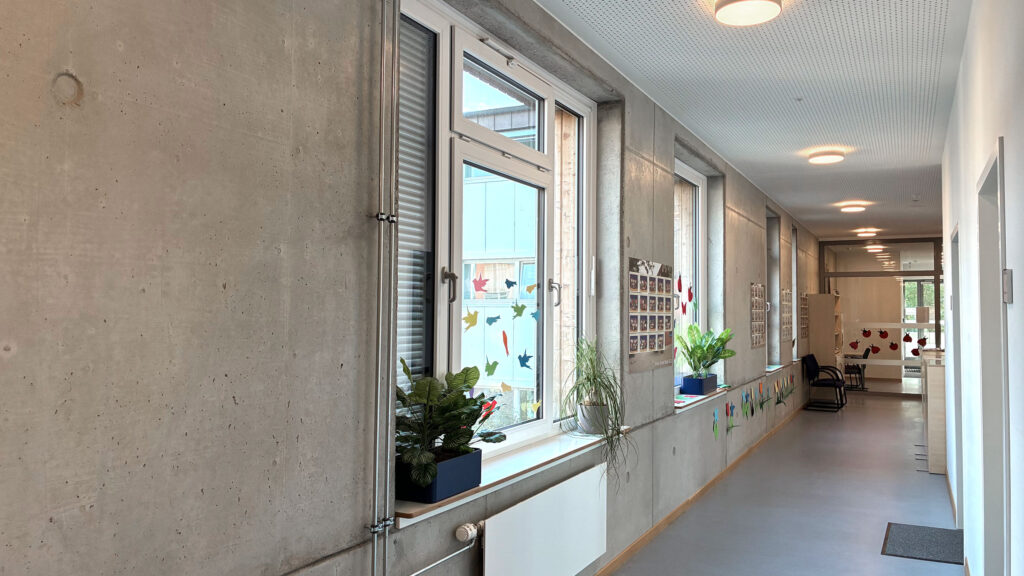 Langer Flur mit Fensterreihe und Pflanzen auf der Fensterbank