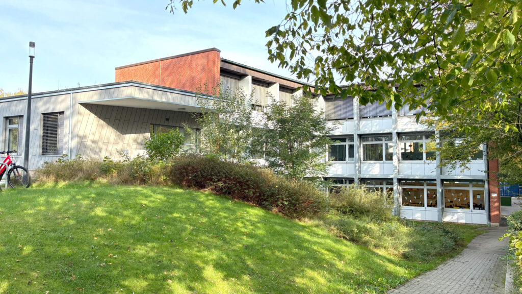 Älteres Schulgebäude hinter einer grünen Wiese