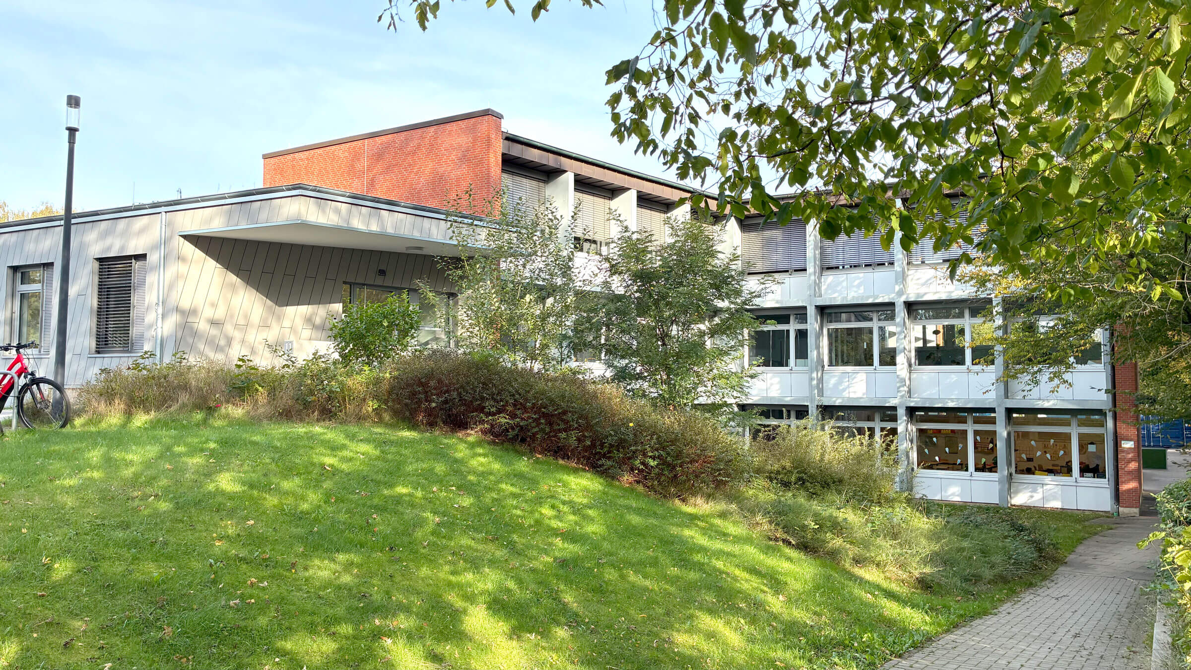 Älteres Schulgebäude hinter einer grünen Wiese
