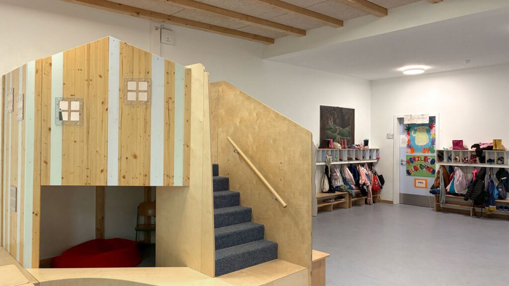 Holzhäuschen mit Treppe und Kuschelecke im Klassenraum der Vorschule