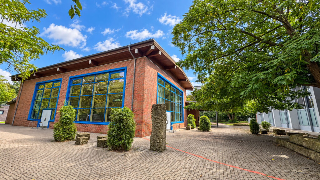 Sporthalle aus Klinker mit großen blauen Fensterflächen